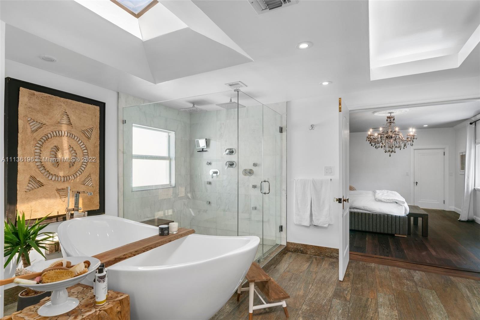 5852 Pine Tree Drive Miami Beach, FL 33140 - Photo 23 of 53 a spacious bathroom with a tub sink and mirror