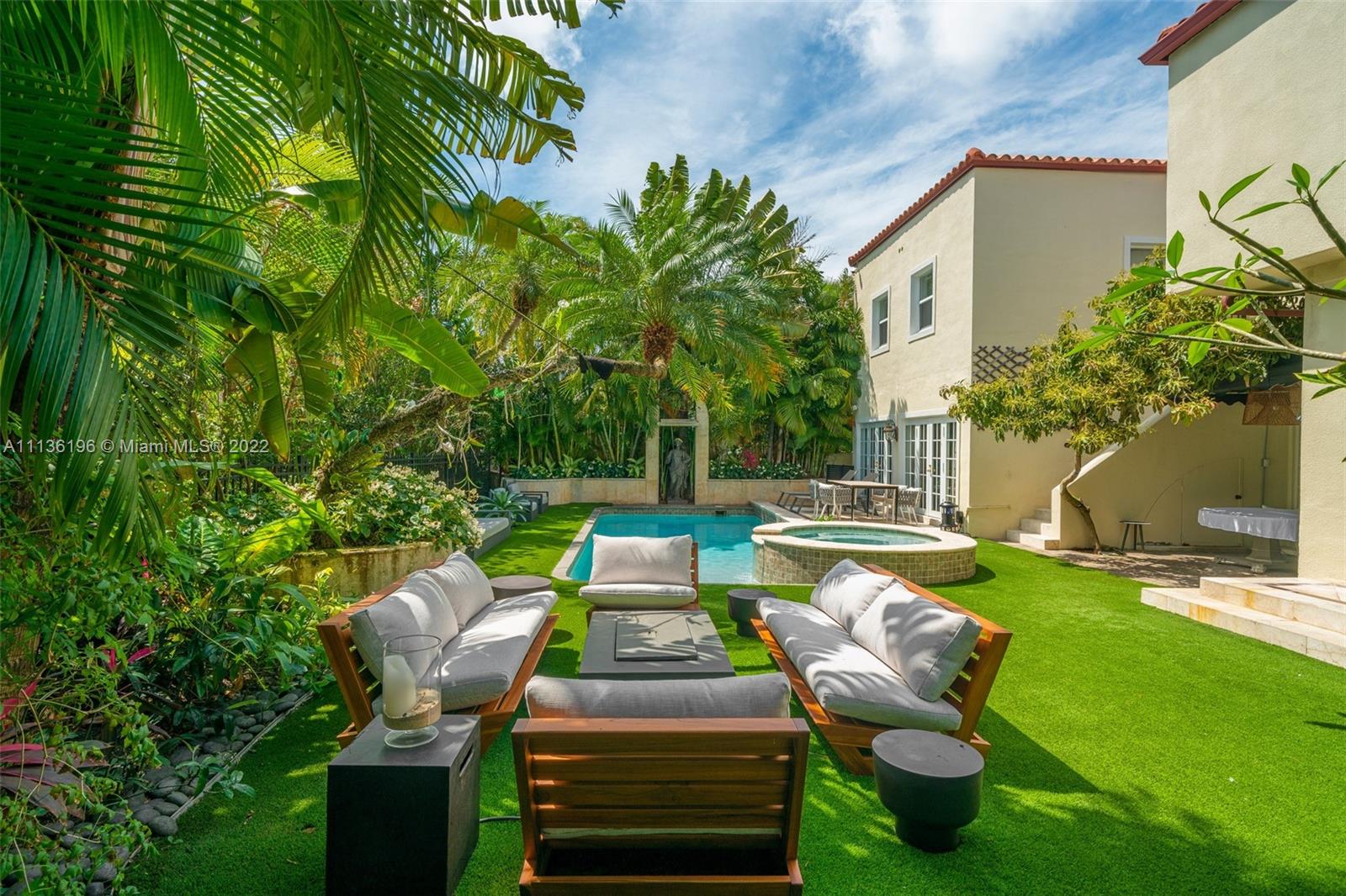 5852 Pine Tree Drive Miami Beach, FL 33140 - Photo 38 of 53 a view of a chairs and table in backyard