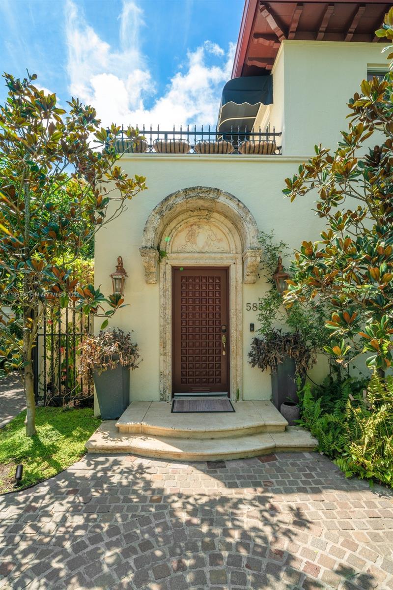 5852 Pine Tree Drive Miami Beach, FL 33140 - Photo 47 of 53 a front view of a house with a garden