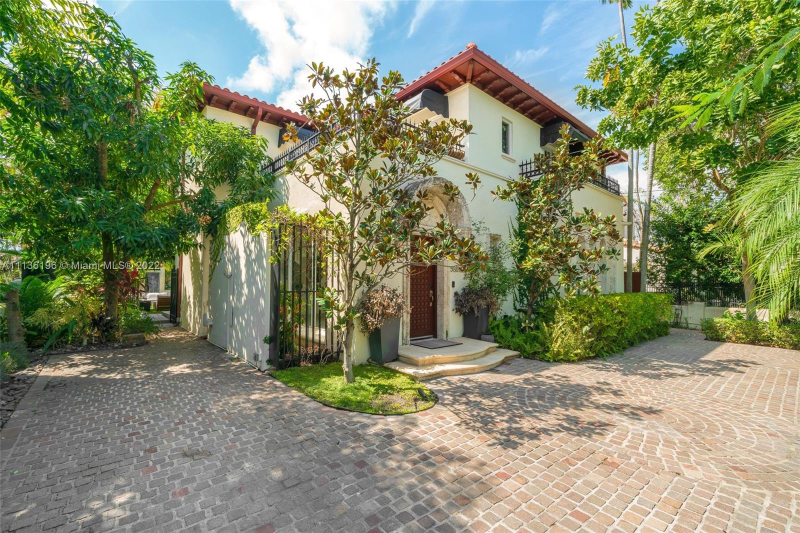 5852 Pine Tree Drive Miami Beach, FL 33140 - Photo 49 of 53 a front view of a house with a yard and tree s