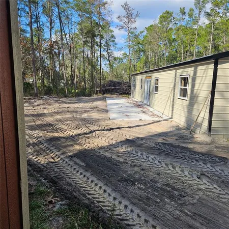 a view of a backyard with large trees