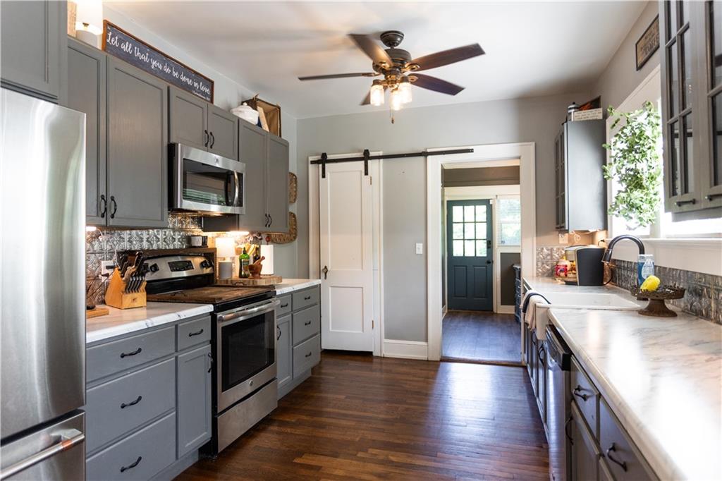 346 North Cherokee Road Social Circle, GA 30025 - Photo 17 of 71 a kitchen with stainless steel appliances a stove a refrigerator a sink a stove and white cabinets with wooden floor