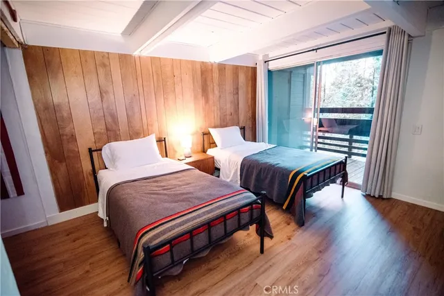 a bedroom with two beds and a wooden floor