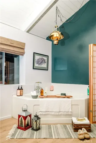 a bedroom with a bed a lamp and paintings on the wall