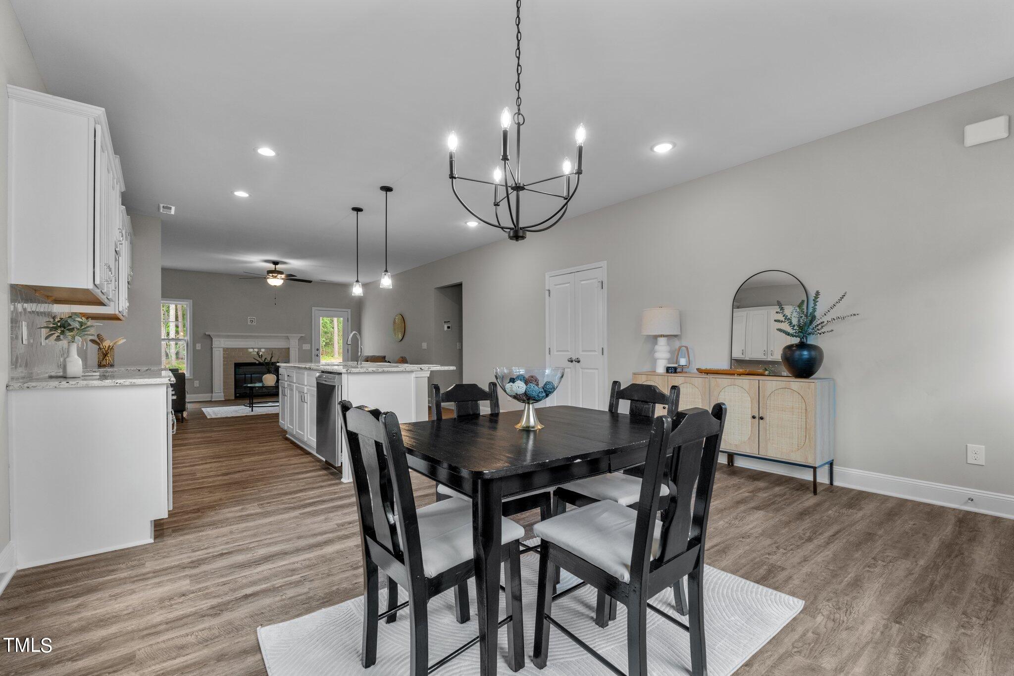 57 Regis Lane Coats, NC 27521 - Photo 12 of 39 a view of a dining room and livingroom with furniture wooden floor a chandelier