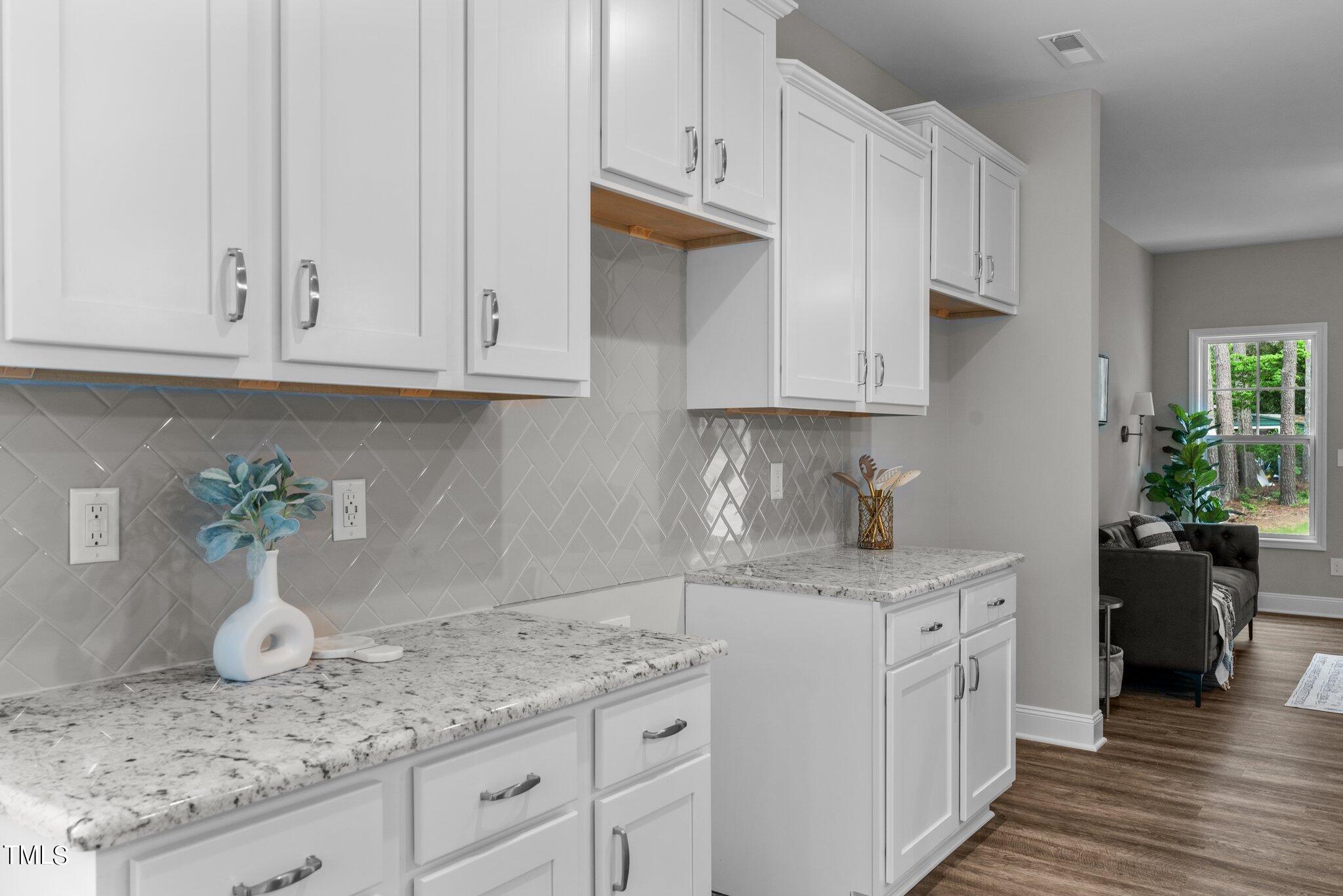 57 Regis Lane Coats, NC 27521 - Photo 16 of 39 a kitchen with granite countertop white cabinets white stove and granite counter tops