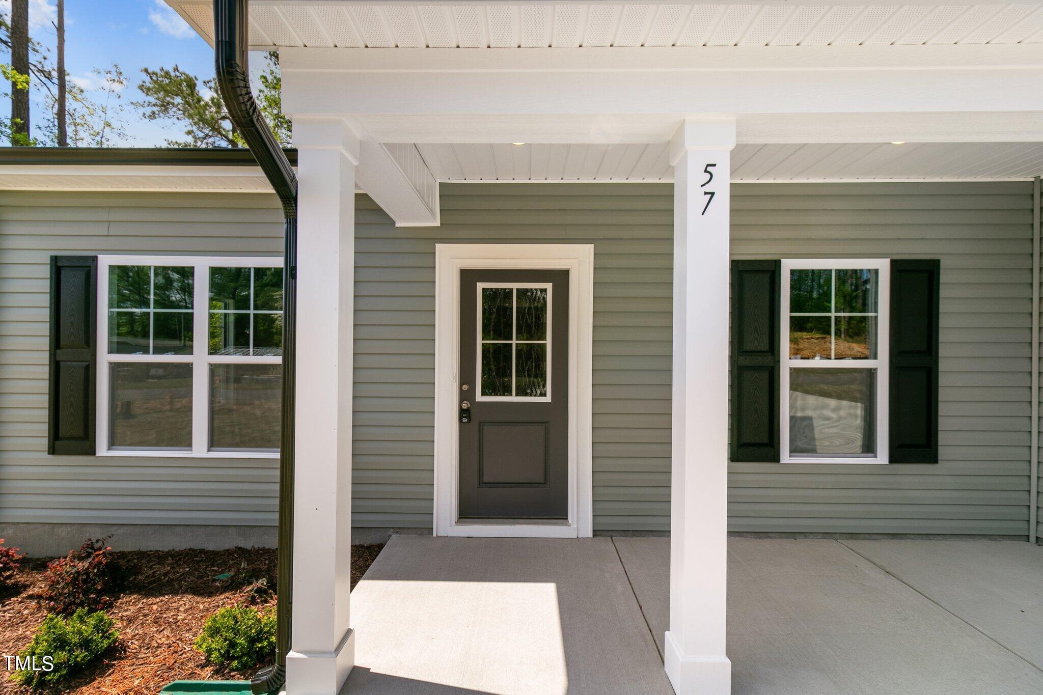 57 Regis Lane Coats, NC 27521 - Photo 2 of 39 a front view of a house with a yard