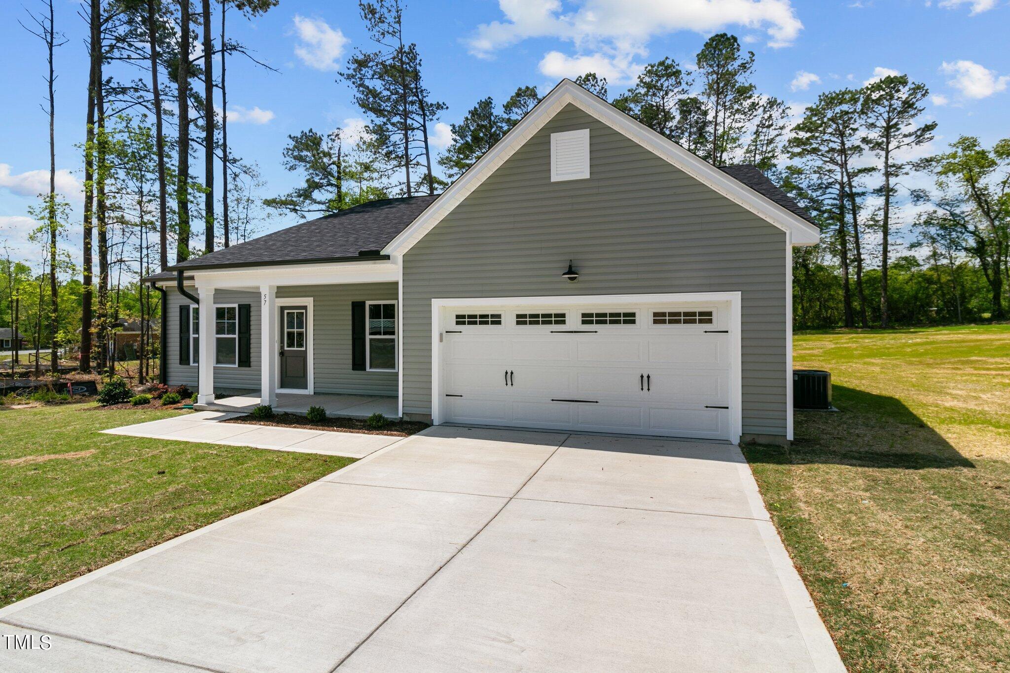 57 Regis Lane Coats, NC 27521 - Photo 4 of 39 a view of a house with a yard and potted plants