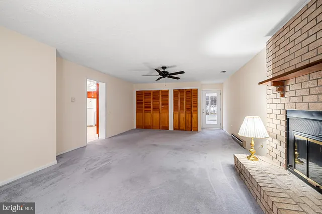 a view of an empty room with window and fireplace