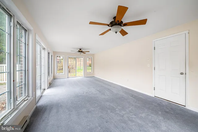 a view of empty room with wooden floor and windows