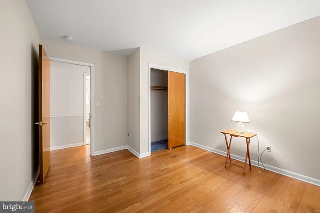 a view of a room with wooden floor a cabinet and windows