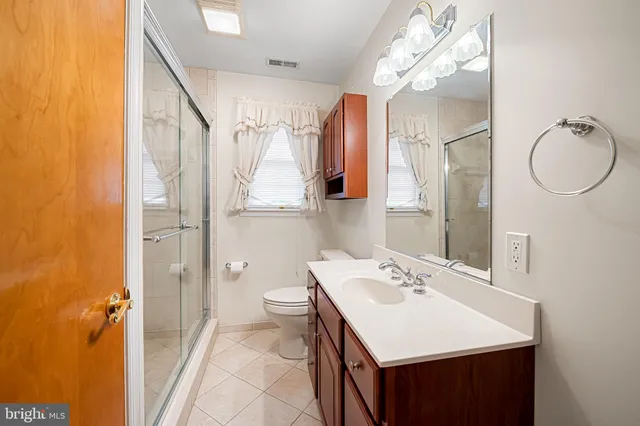 a bathroom with a sink vanity mirror and toilet