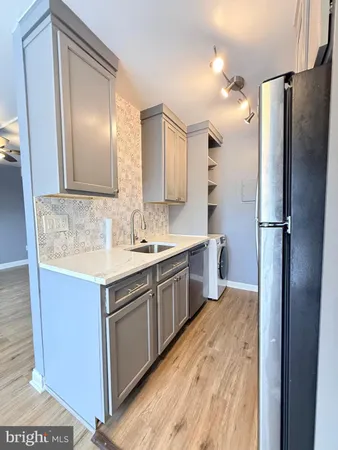 a kitchen with a sink refrigerator and cabinets