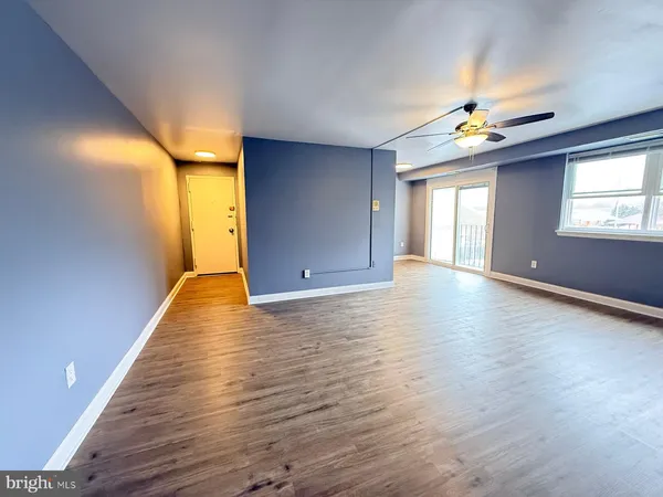 a view of an empty room with window and wooden floor