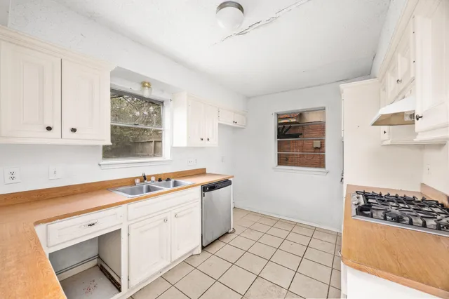 a kitchen with white cabinets and appliances