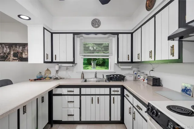 a kitchen with a sink cabinets appliances and a window