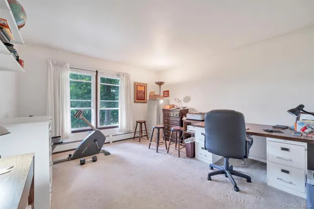 a view of a workspace with furniture and a window