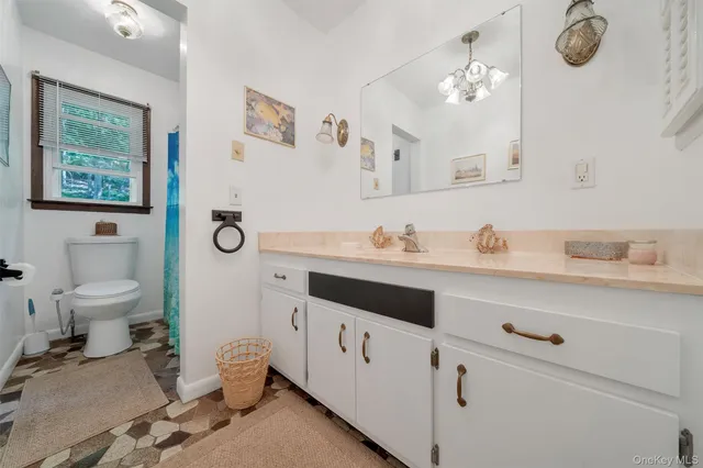 a bathroom with a sink a toilet and a mirror