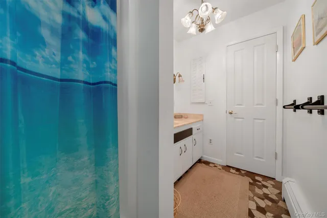 a view of a hallway with closet and chandelier