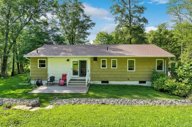 a view of a house with a yard table and chairs