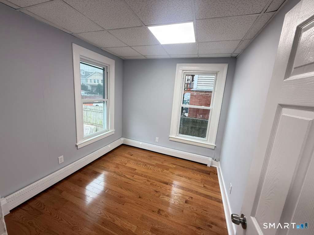 276 Pequonnock Street, Unit 1 Bridgeport, CT 06604 - Photo 5 of 9 a view of an empty room with wooden floor and a window