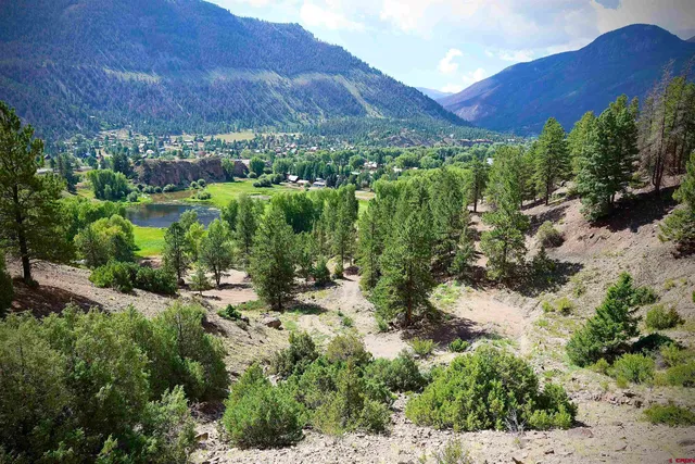 a view of a lush green hillside and houses