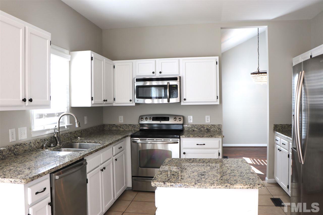 5713 Edgebury Road Raleigh, NC 27613 - Photo 11 of 26 a kitchen with stainless steel appliances granite countertop a stove a sink and a microwave