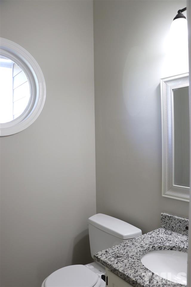 5713 Edgebury Road Raleigh, NC 27613 - Photo 13 of 26 a bathroom with a granite countertop toilet and a sink