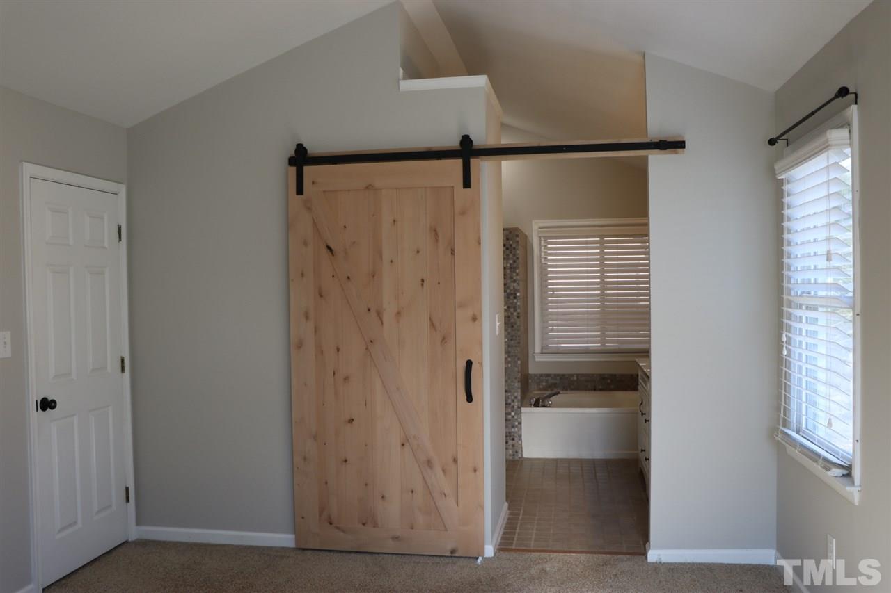 5713 Edgebury Road Raleigh, NC 27613 - Photo 15 of 26 a bathroom with a shower and a window