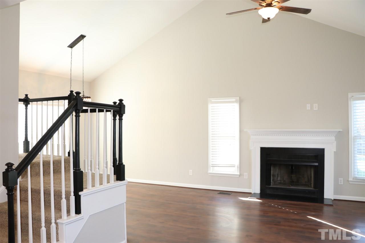 5713 Edgebury Road Raleigh, NC 27613 - Photo 6 of 26 a view of a livingroom with a fireplace a ceiling fan and wooden floor