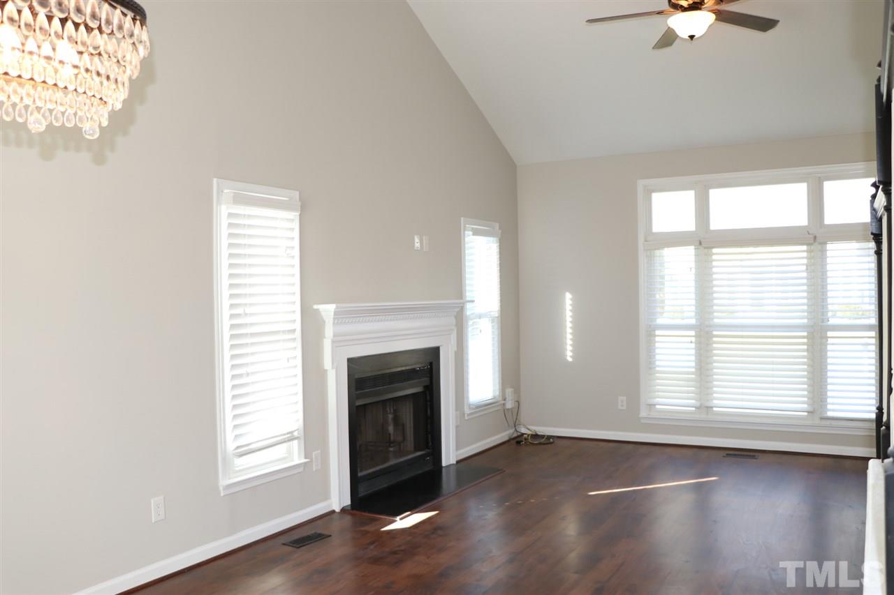 5713 Edgebury Road Raleigh, NC 27613 - Photo 8 of 26 a view of empty room with fireplace and wooden floor