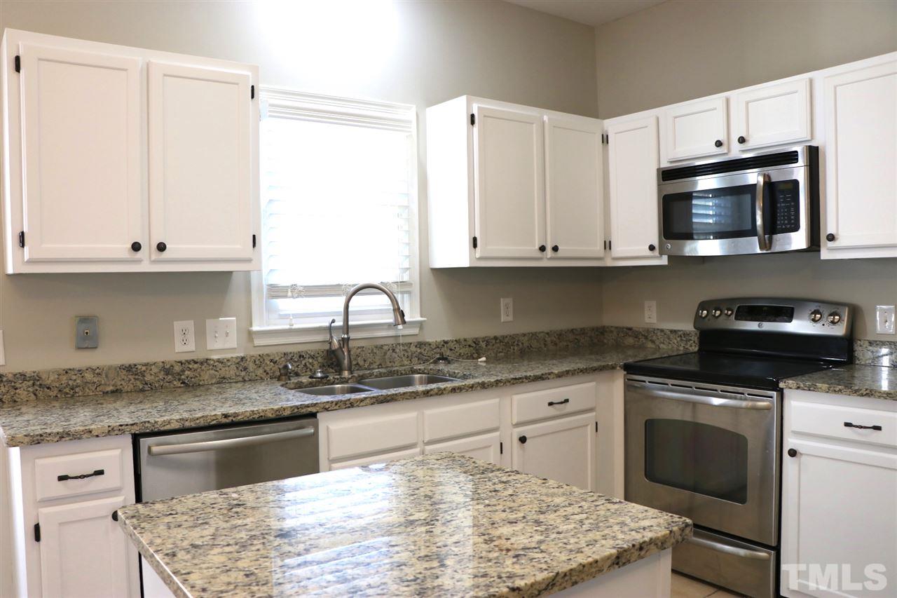 5713 Edgebury Road Raleigh, NC 27613 - Photo 9 of 26 a kitchen with granite countertop white cabinets and stainless steel appliances