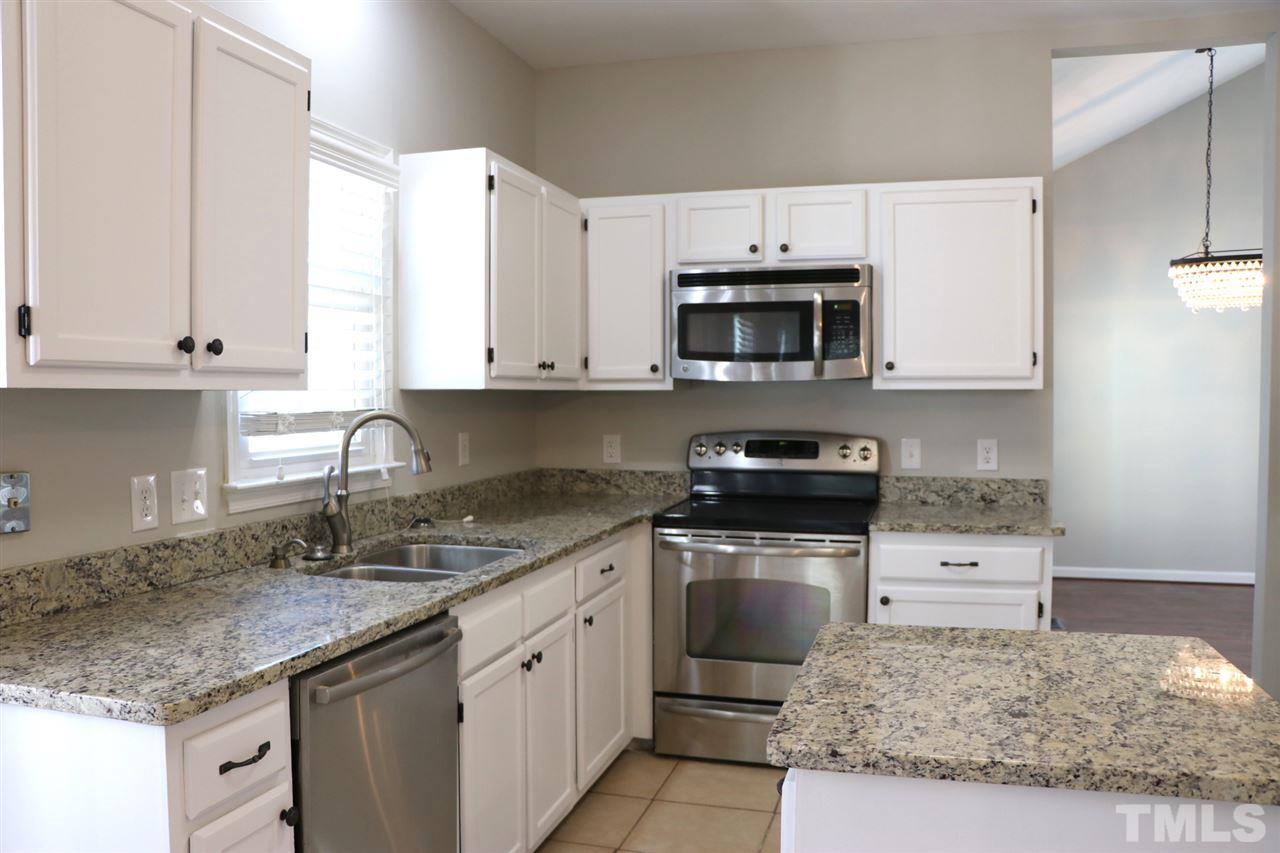 5713 Edgebury Road Raleigh, NC 27613 - Photo 10 of 26 a kitchen with granite countertop a sink stove and microwave
