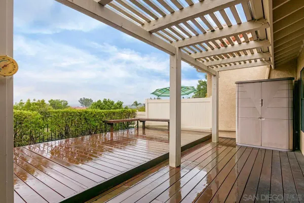 a view of a balcony with wooden floor and outdoor seating