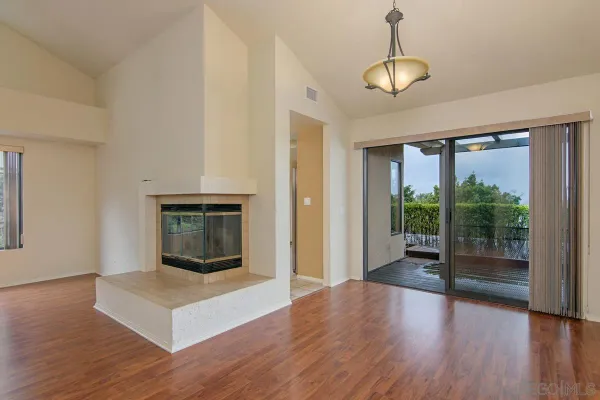 a living room with wooden floor and a fireplace