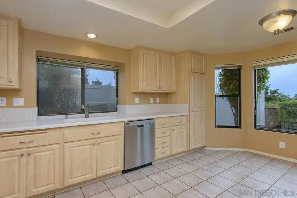 a kitchen with white cabinets and sink