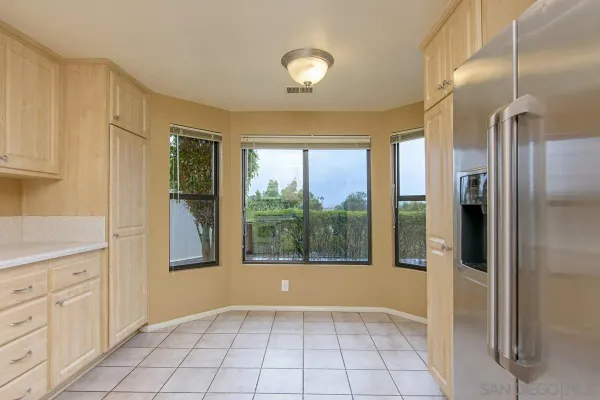 a view of an empty room with window and cabinet