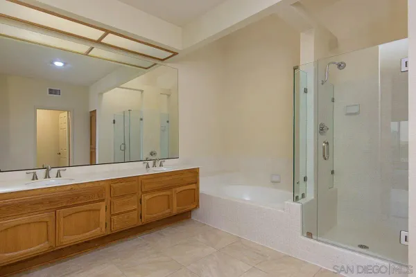 a spacious bathroom with a mirror a shower and a bathtub
