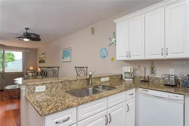 a kitchen with granite countertop a sink a stove and cabinets