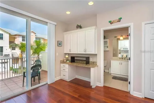 a kitchen with a refrigerator and wooden floor