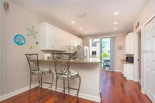 a view of a kitchen with furniture and wooden floor