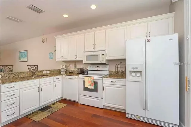 a kitchen with white cabinets and white appliances
