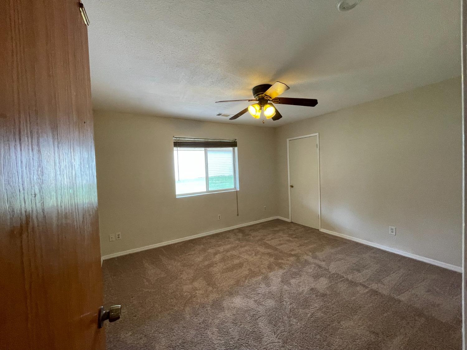 2344 Tivy Valley Road Sanger, CA 93657 - Photo 26 of 61 an empty room with windows and chandelier fan