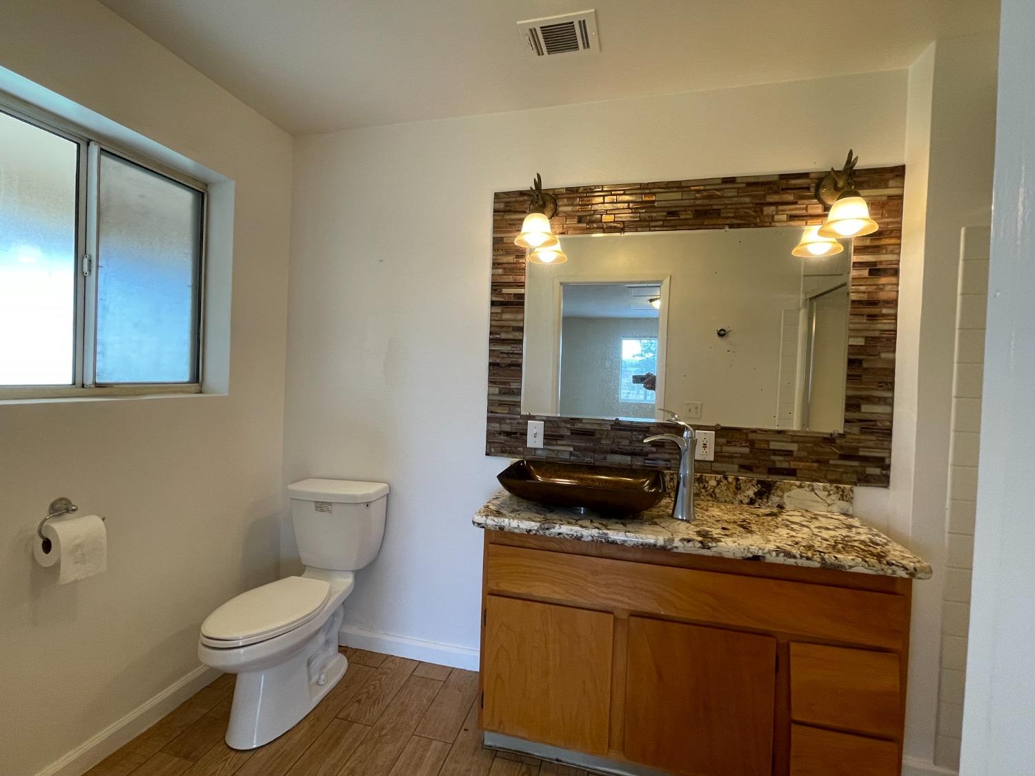 2344 Tivy Valley Road Sanger, CA 93657 - Photo 30 of 61 a bathroom with a granite countertop sink mirror vanity and toilet