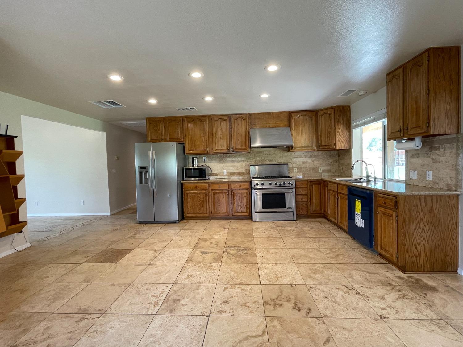 2344 Tivy Valley Road Sanger, CA 93657 - Photo 8 of 61 a large kitchen with stainless steel appliances granite countertop a stove top oven a sink dishwasher and a refrigerator