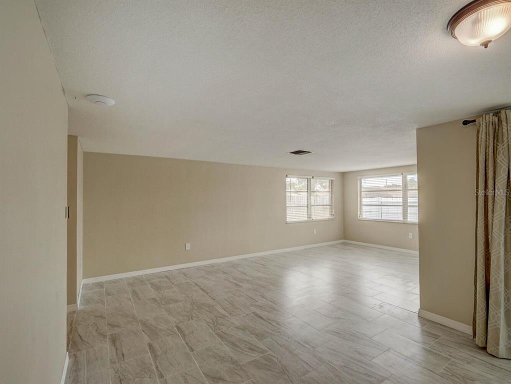 10320 Honeysuckle Lane Port Richey, FL 34668 - Photo 12 of 53 a view of empty room with wooden floor and fan