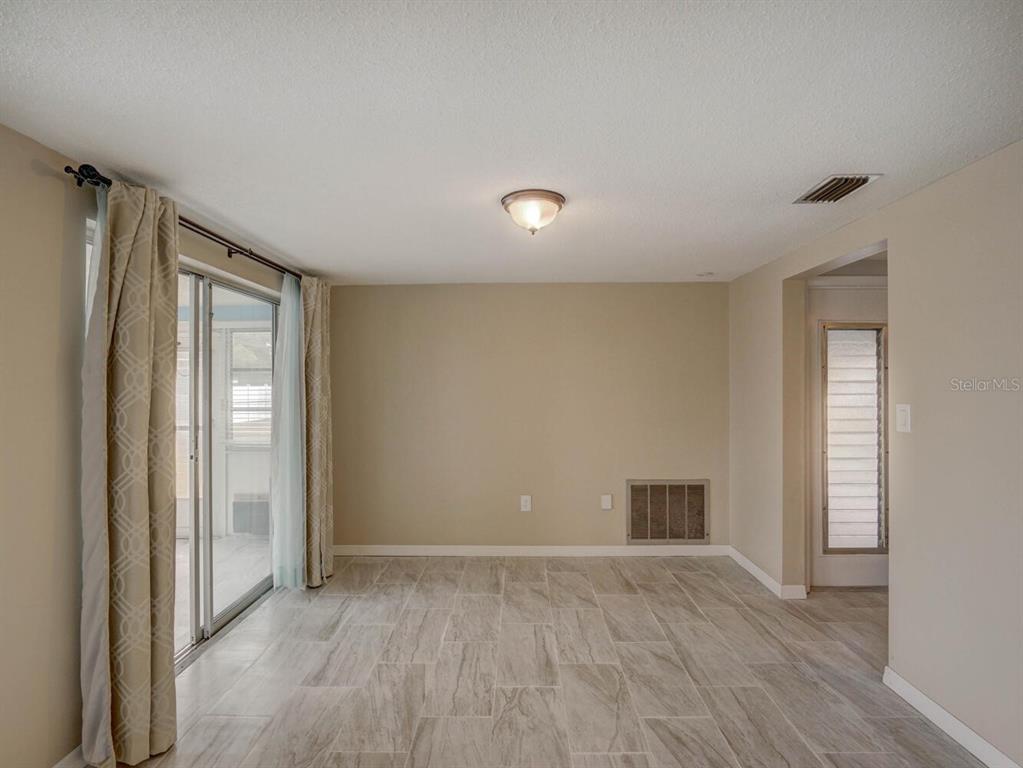 10320 Honeysuckle Lane Port Richey, FL 34668 - Photo 13 of 53 a view of an empty room with wooden floor and a window