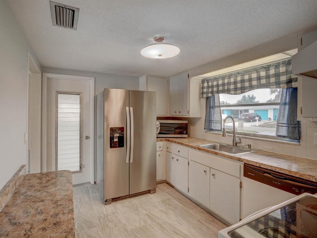 10320 Honeysuckle Lane Port Richey, FL 34668 - Photo 15 of 53 a kitchen with a refrigerator sink and cabinets