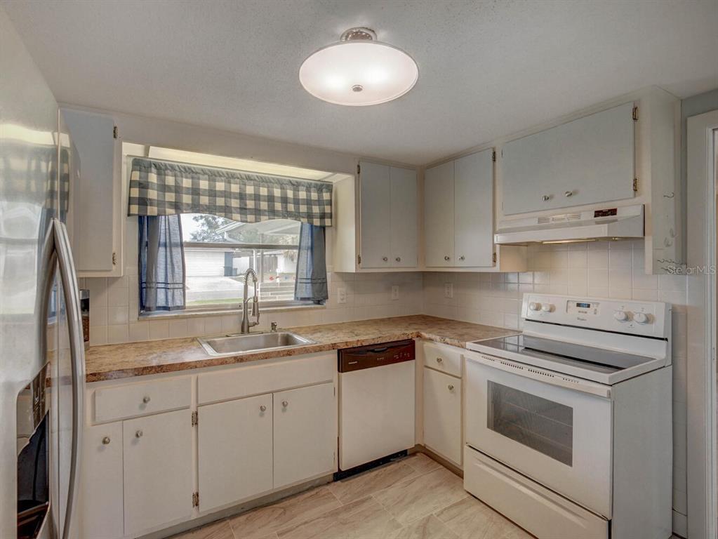 10320 Honeysuckle Lane Port Richey, FL 34668 - Photo 18 of 53 a kitchen with cabinets appliances a sink and a window