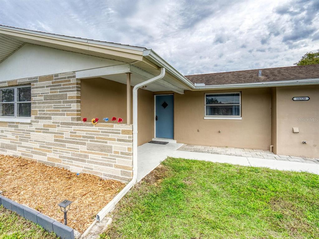 10320 Honeysuckle Lane Port Richey, FL 34668 - Photo 4 of 53 a front view of a house with a yard